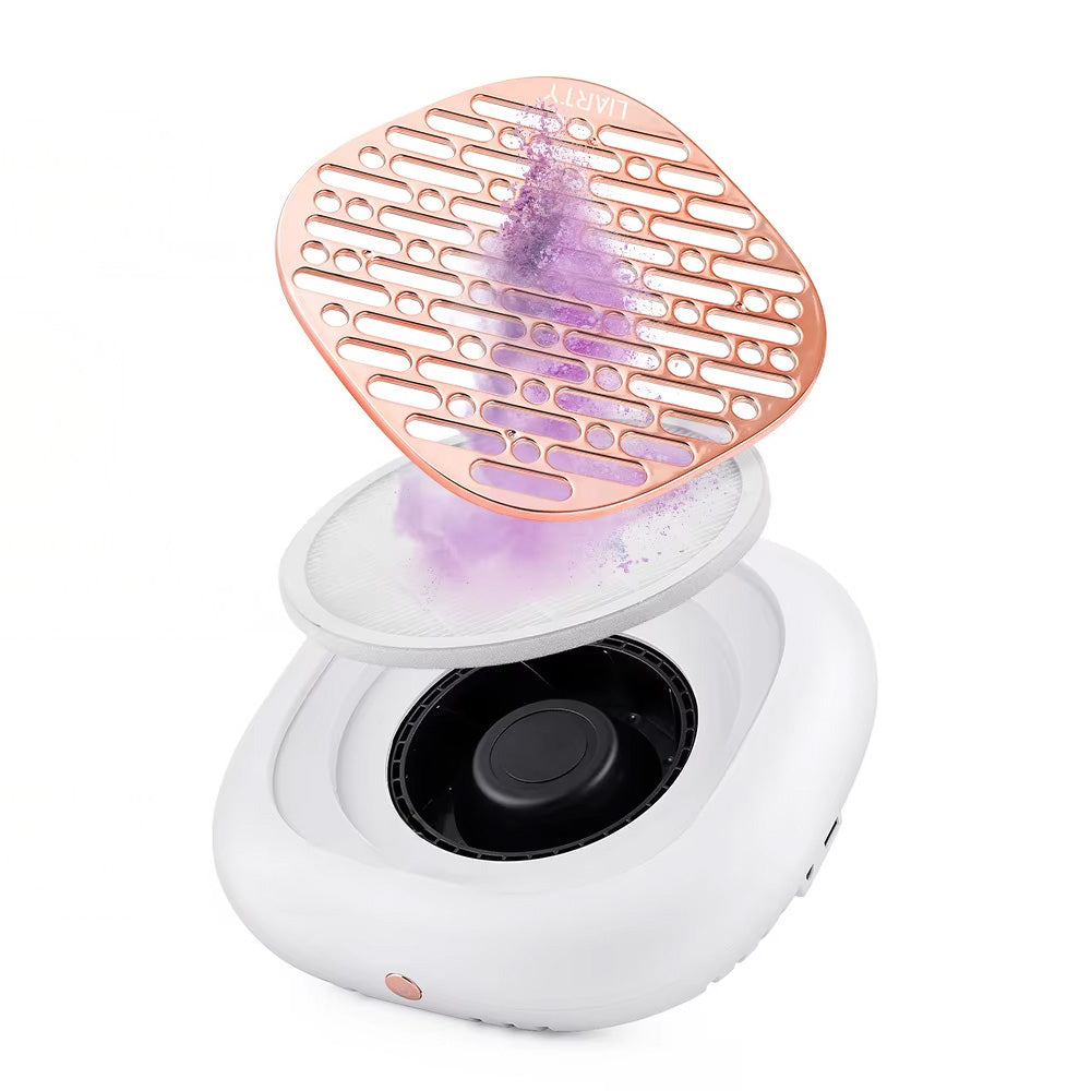 Vue interne de l’aspirateur à ongles ouvert, montrant le système de filtration double avec la poussière violette captée par le filtre rond placé sous la grille dorée.