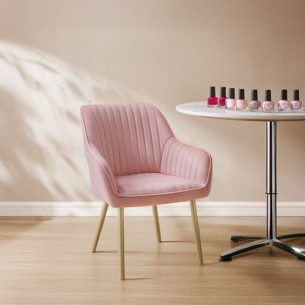 Chaise manucure en velours rose dans une pièce lumineuse, associée à une table ronde avec des vernis à ongles.
