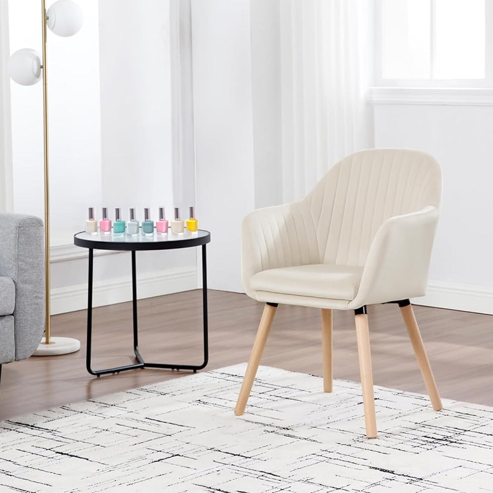 Chaise manucure en tissu beige avec dossier strié et pieds en bois naturel, placée dans un salon moderne aux tons neutres, accompagnée d'une table avec vernis à ongles colorés. Design élégant et confortable.