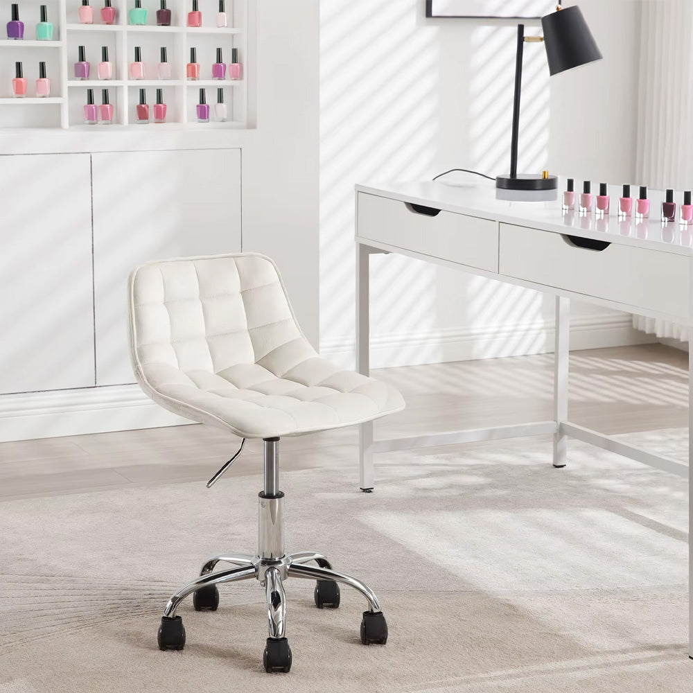 Chaise blanche installée dans un salon de manucure lumineux avec une table et des vernis à ongles.