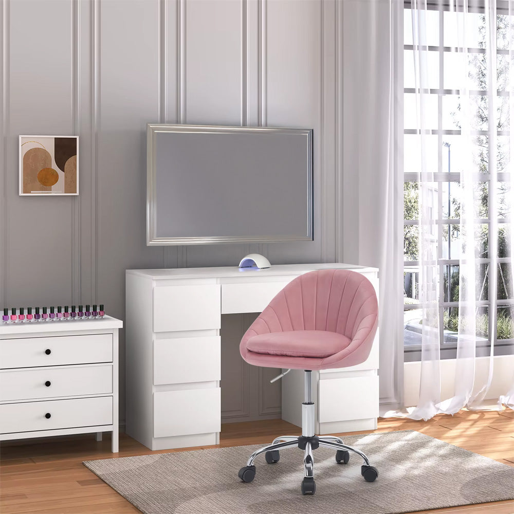 Chaise prothésiste ongulaire rose placée devant une coiffeuse blanche avec rangements, dans une pièce lumineuse et élégante.