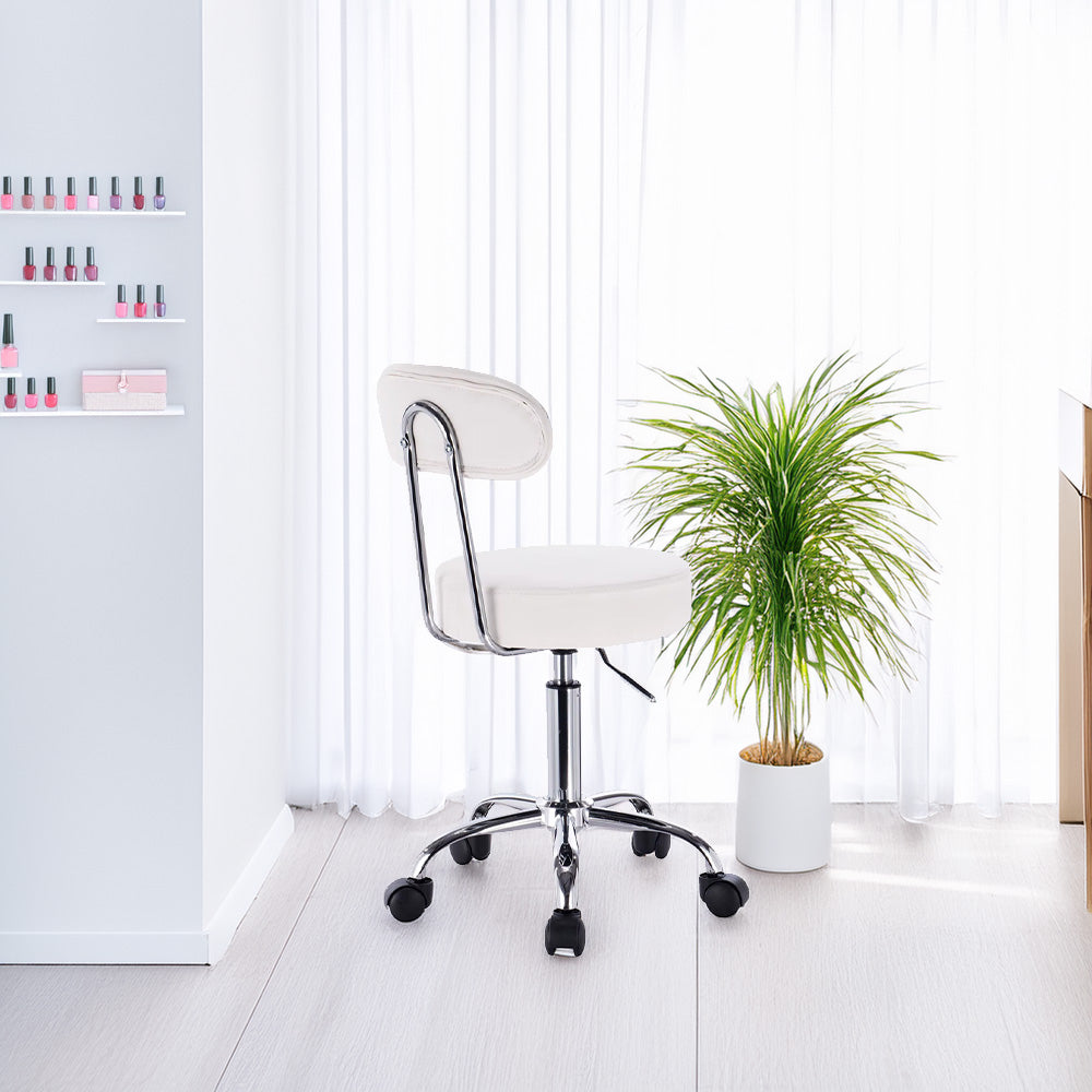 Chaise ergonomique blanche placée dans un salon de manucure avec plantes et décoration épurée
