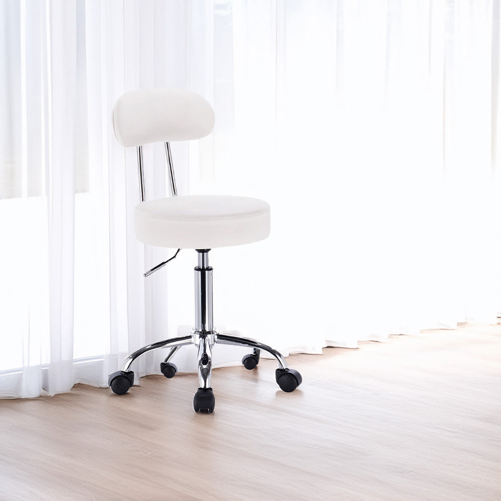 Chaise blanche avec roulettes dans un intérieur lumineux avec rideaux blancs et parquet clair