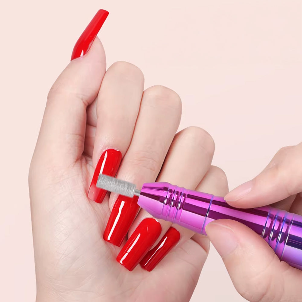 Utilisation de la ponceuse électrique sur des ongles en gel longs et rouges, démontrant sa capacité à limer et sculpter avec précision.