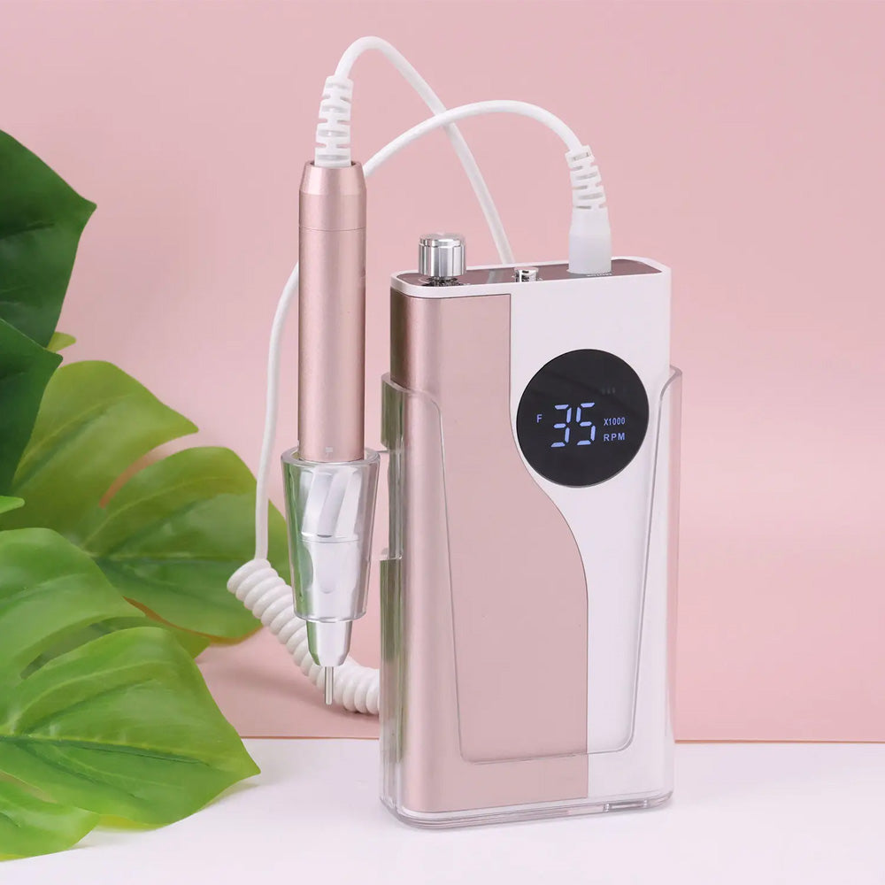 Ponceuse ongle sans fil avec support pratique et rangement intégré - Version rose et blanche placée dans un support transparent, avec un porte-stylet intégré.