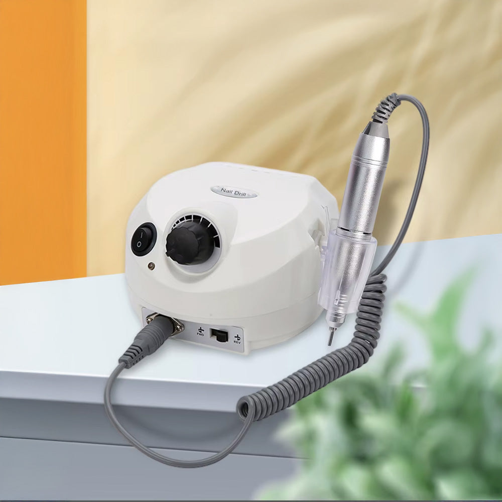 Ponceuse à ongles professionnelle blanche 35000 RPM posée sur une table – Outil puissant avec pièce à main en métal et support intégré.