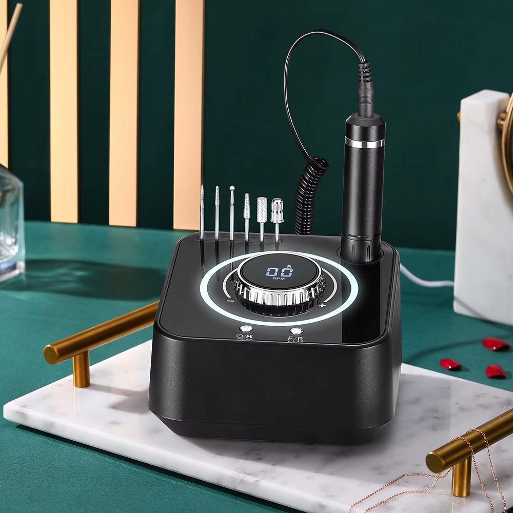 Ponceuse à ongles professionnelle noire mise en scène sur une table, soulignant son design élégant et son aspect haut de gamme.