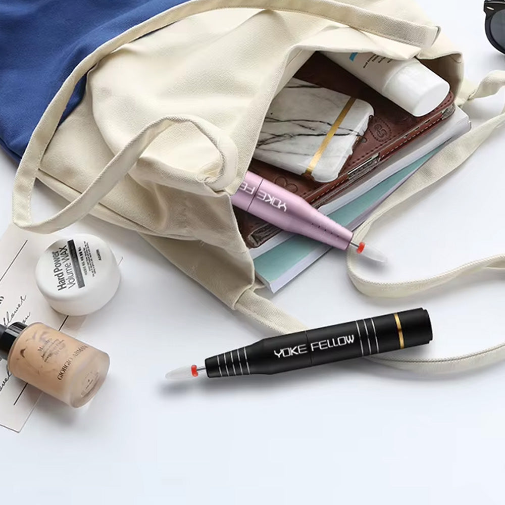 Ponceuses à ongles sans fil 30 000 RPM en rose et noir glissées dans un sac, illustrant leur format compact et facile à transporter pour une utilisation nomade.